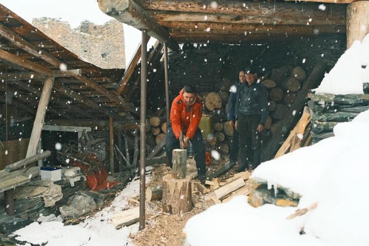 due uomini in piedi in un edificio con una pila di tronchi
