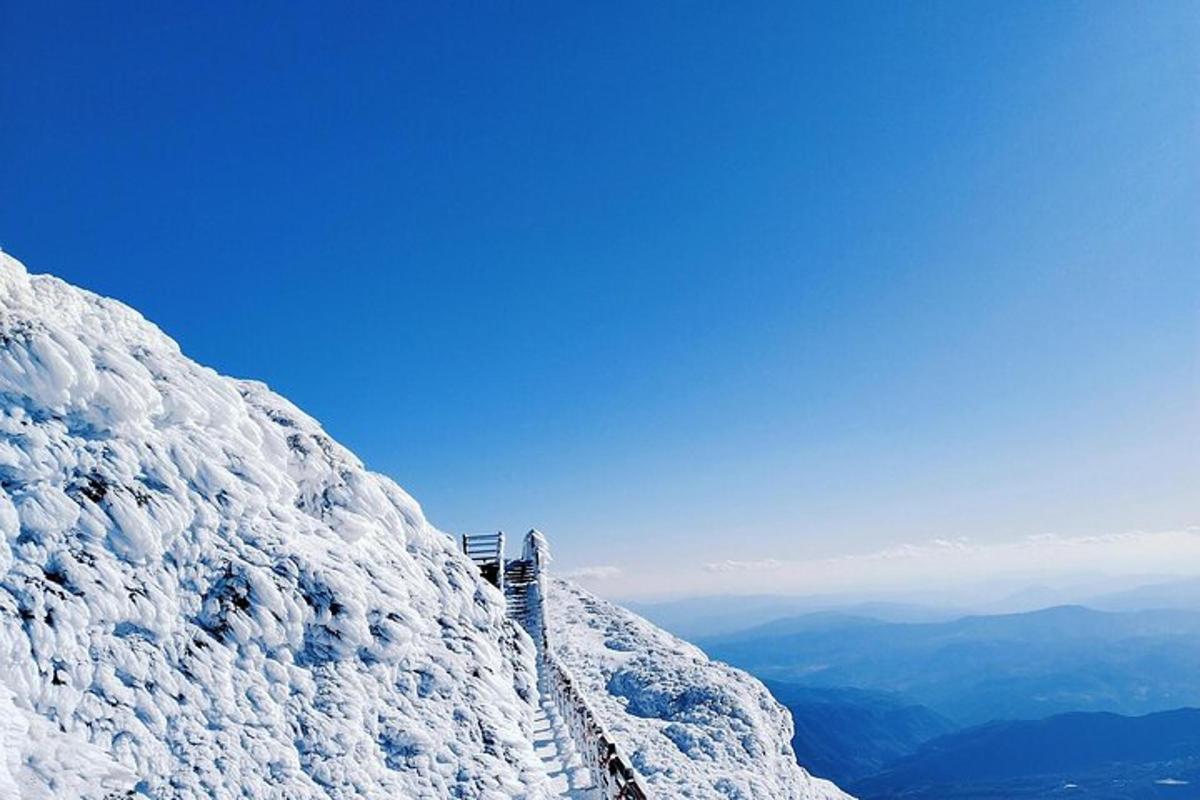 a view of a snow covered mountain with a sky