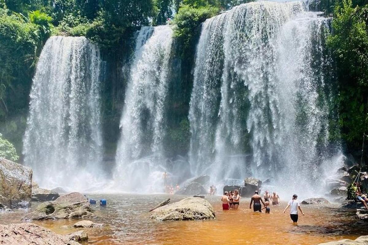 một nhóm người dưới nước trước thác nước