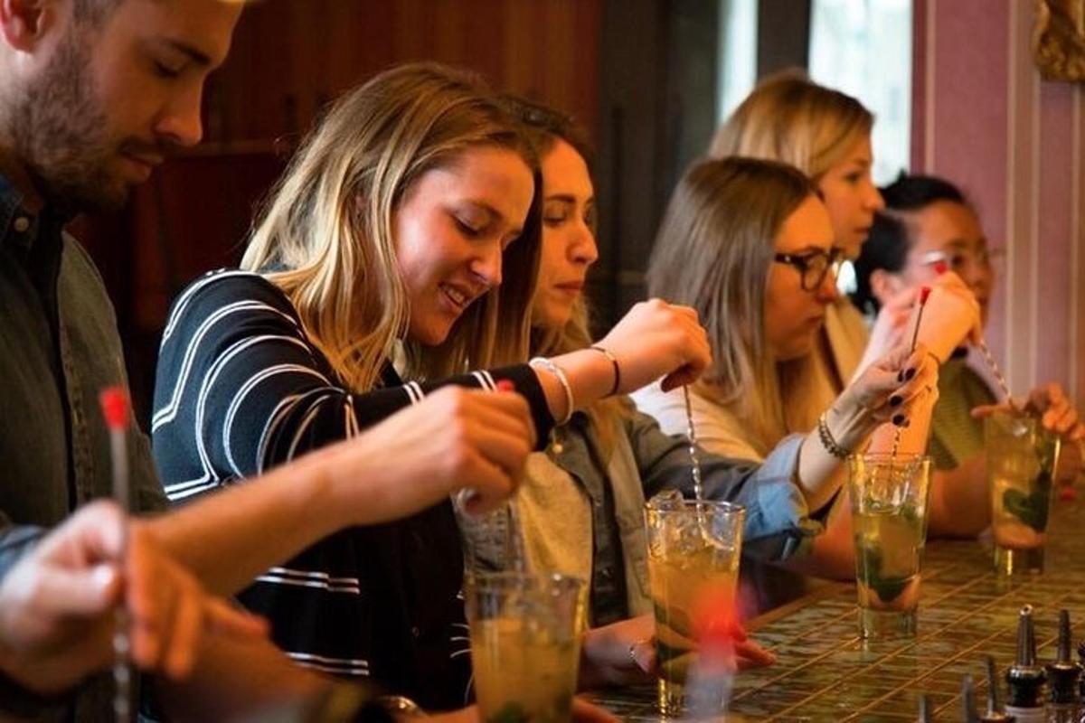 een groep mensen die aan een tafel zitten met drankjes