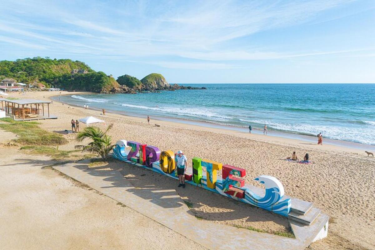 Un tren en una playa con gente en la playa.