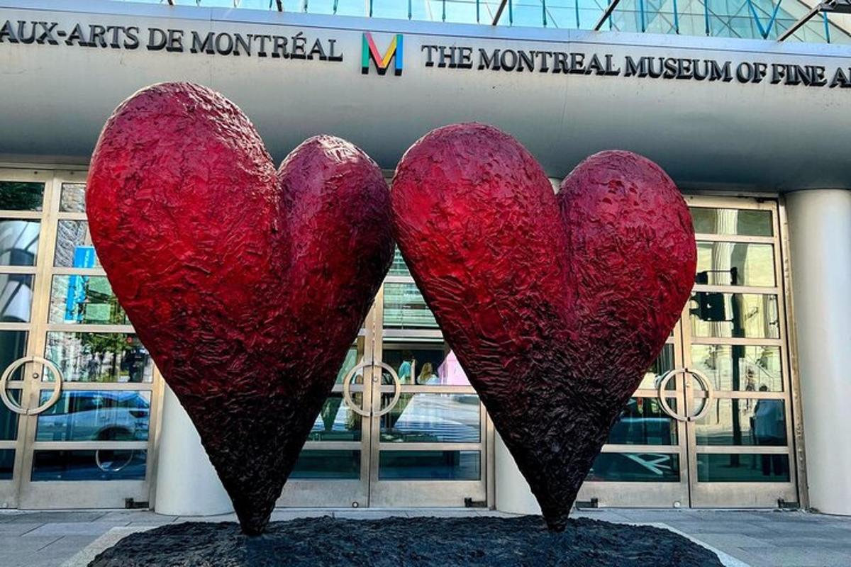 two red heart sculptures in front of a building
