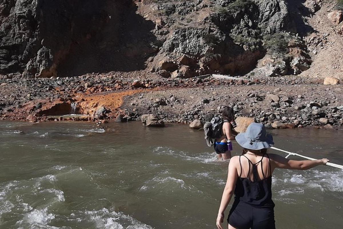 two people are crossing a river with a boat
