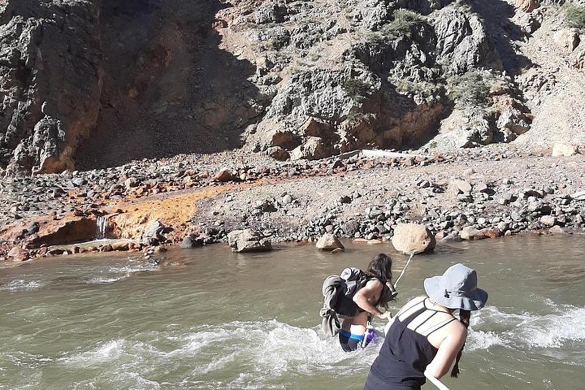 a couple of people crossing a river