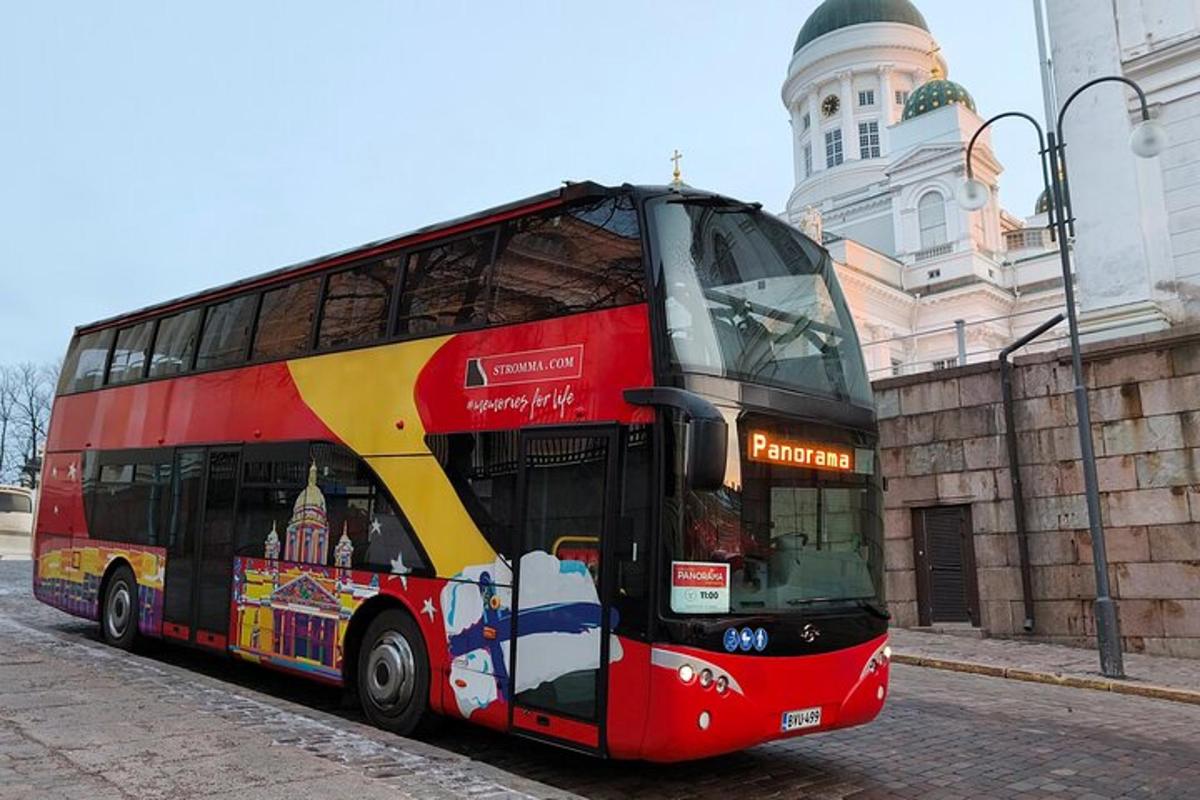 Egy piros emeletes busz parkolt egy épület előtt