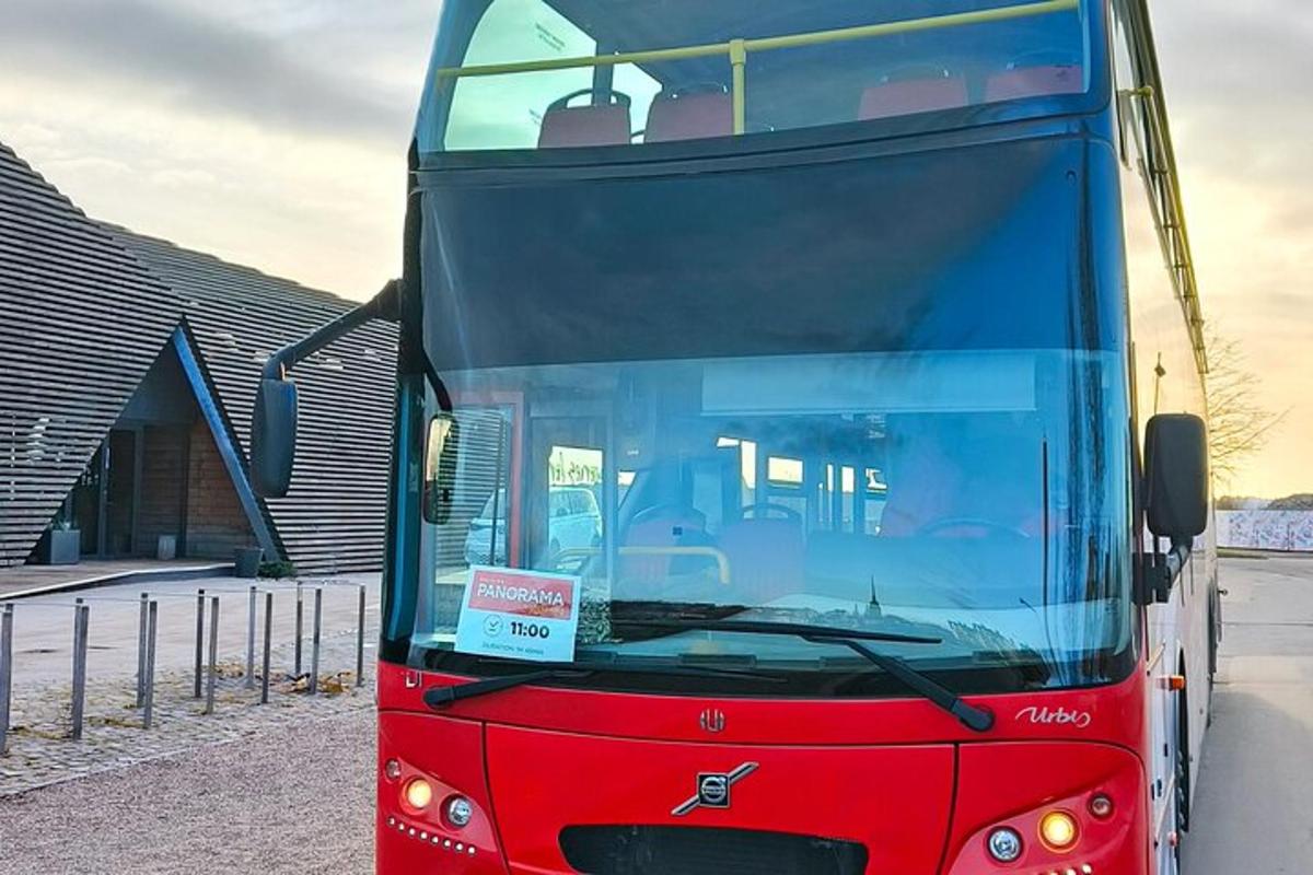 a red double decker bus parked next to a building