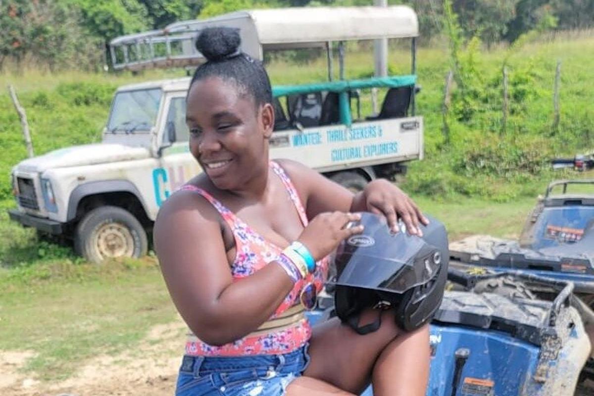 una dona jove asseguda en una motocicleta amb un casc