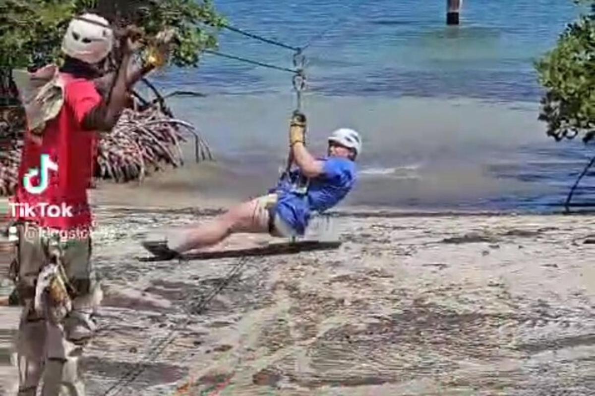 un uomo su un'altalena di corda vicino all'acqua