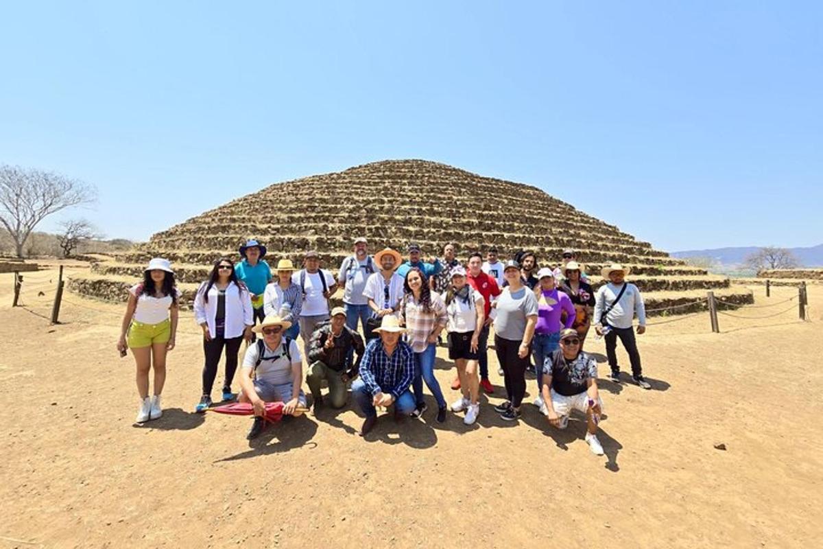 skupina lidí pózujících pro fotografii před pyramidou