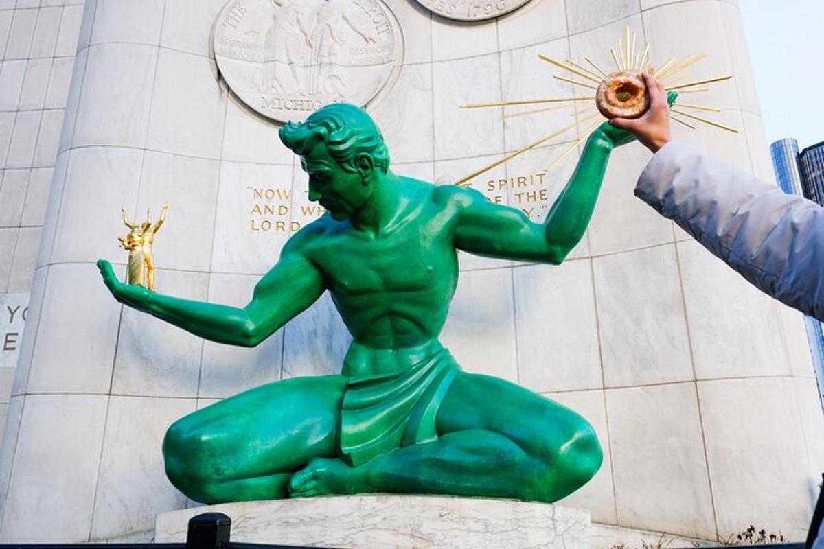 una persona tomando una fotografía de una estatua verde