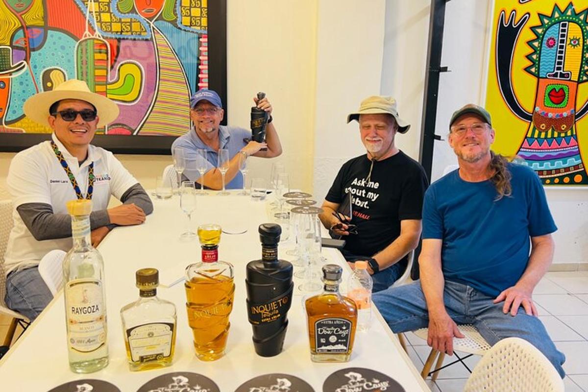 skupina mužů sedících kolem stolu s lahvemi alkoholu