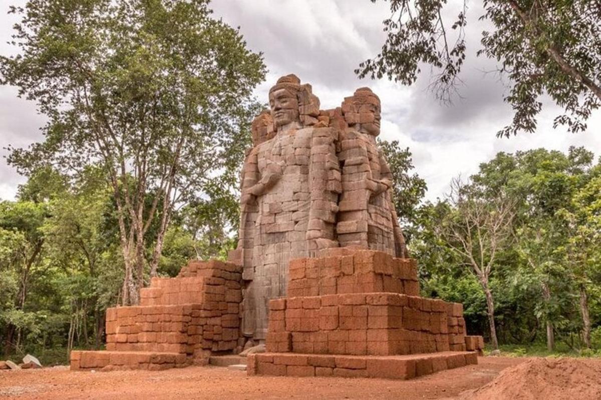 una gran estàtua de pedra al mig d'un camp