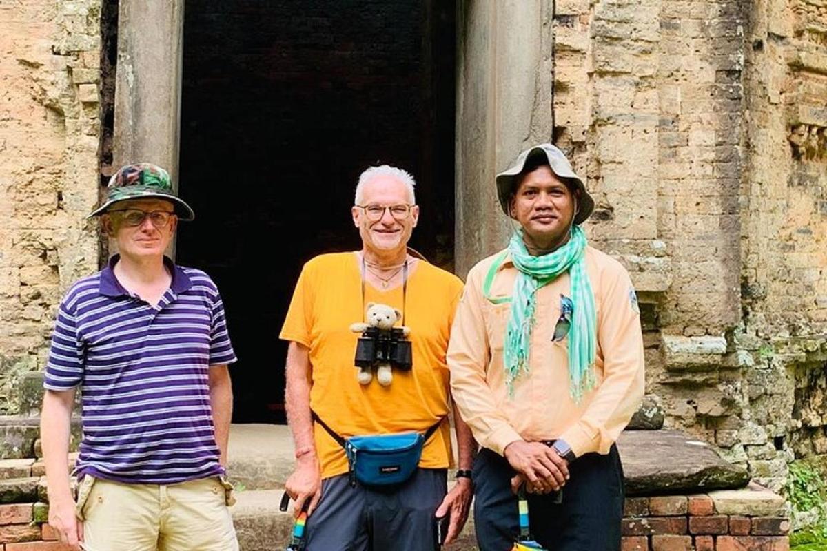 tres persones dempeus davant d'un edifici