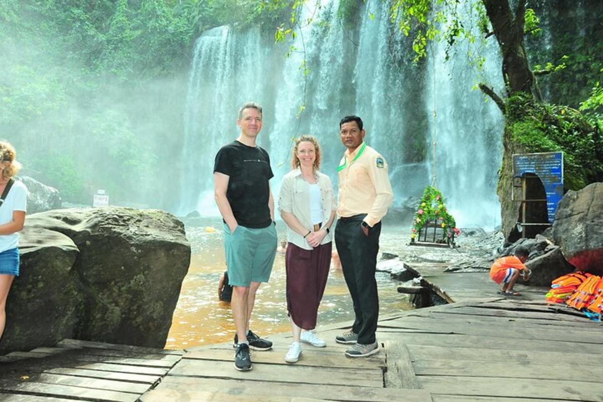 un grup de persones dempeus davant d'una cascada
