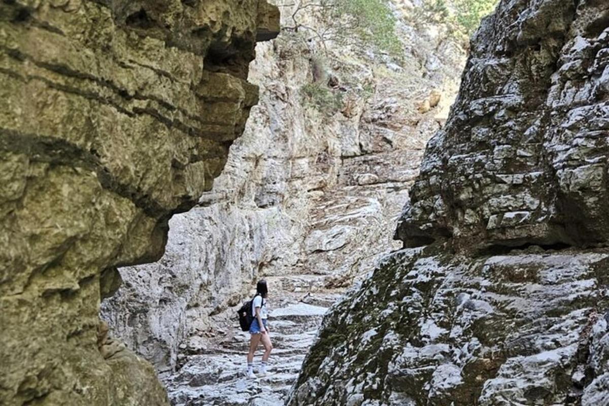 Μια γυναίκα περπατάει μέσα από ένα βραχώδες φαράγγι