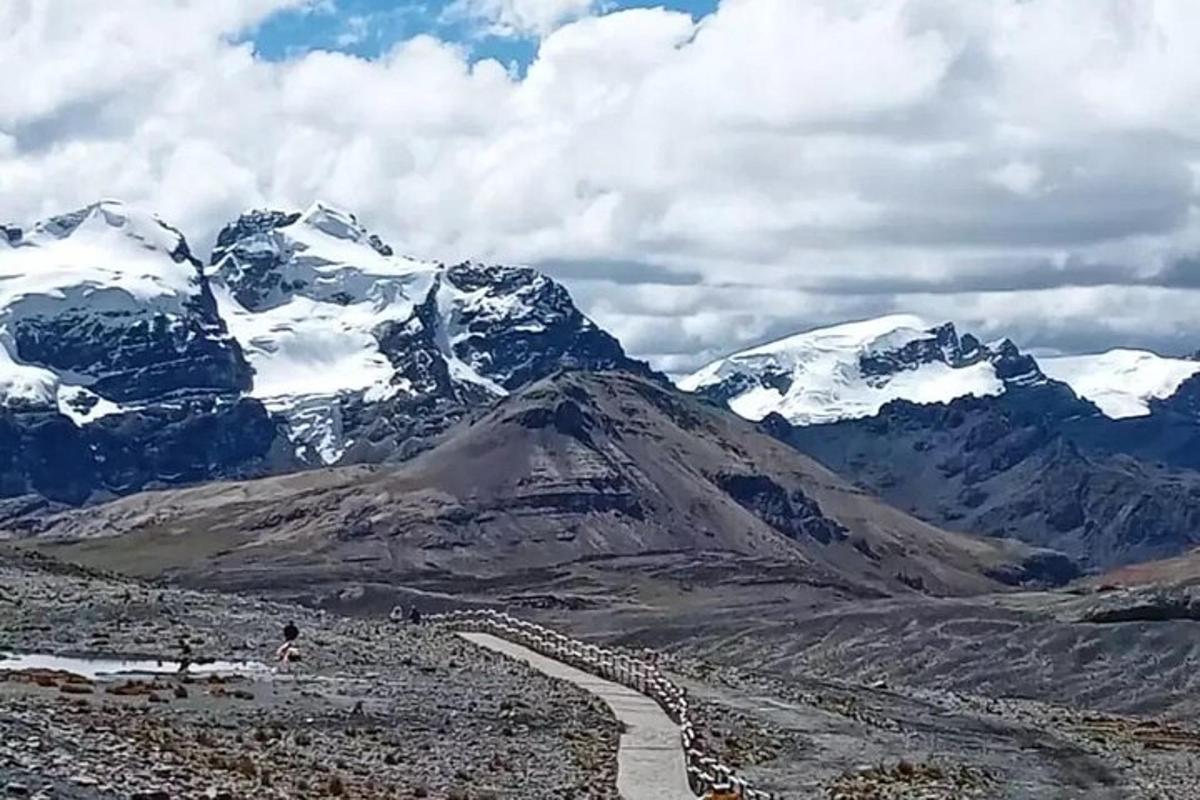 Una montaña con montañas cubiertas de nieve en la distancia