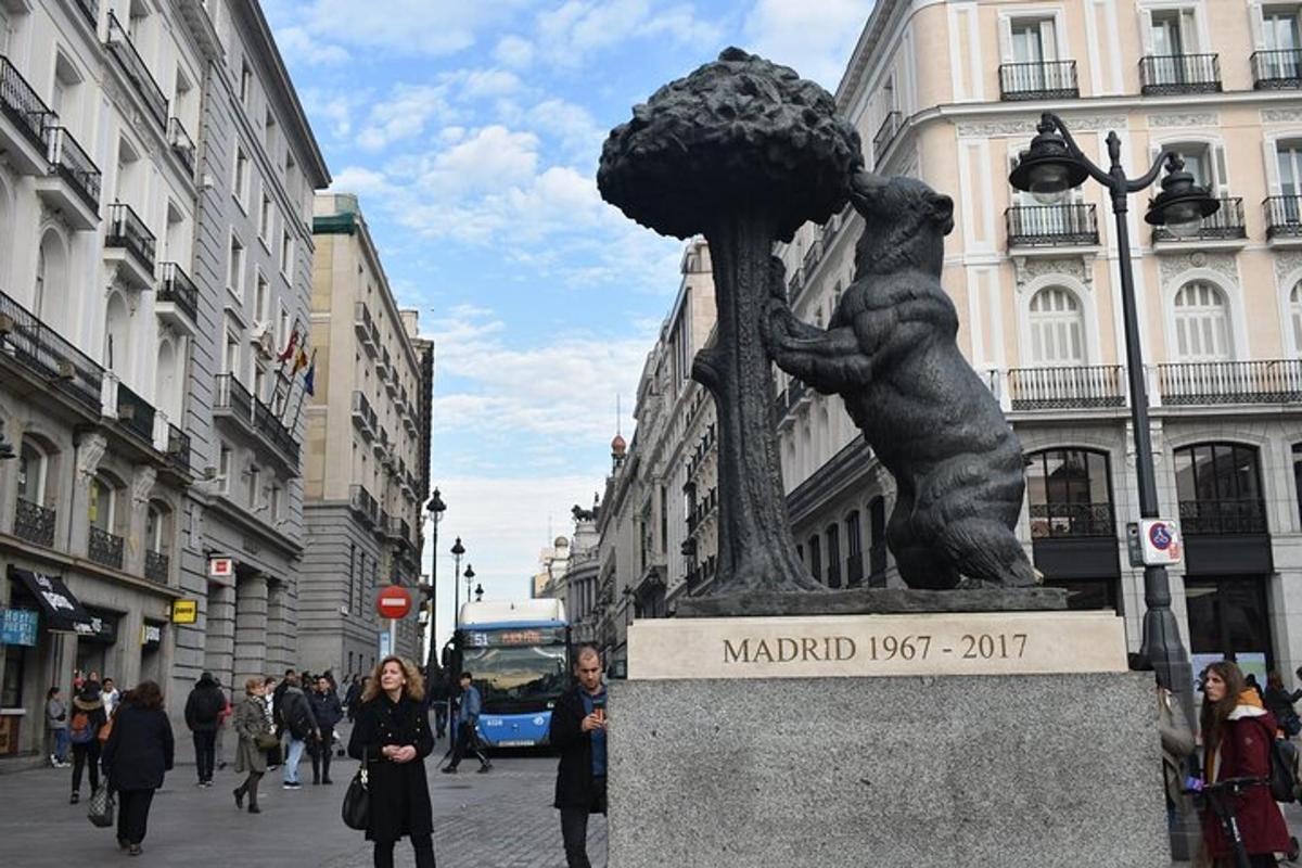 a statue of a bear holding a tree on a street