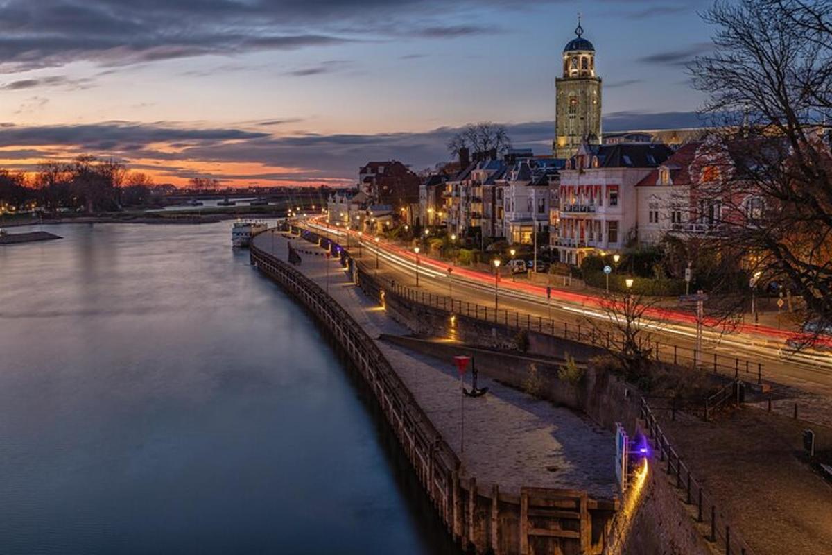 Una ciudad con una torre de reloj y un río por la noche.