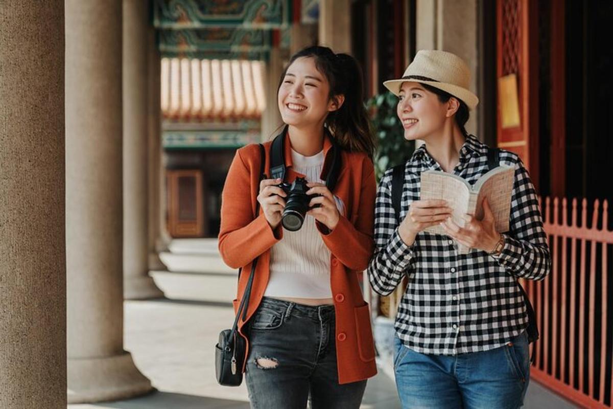 hai người phụ nữ đang đi bộ trên phố với một chiếc máy ảnh
