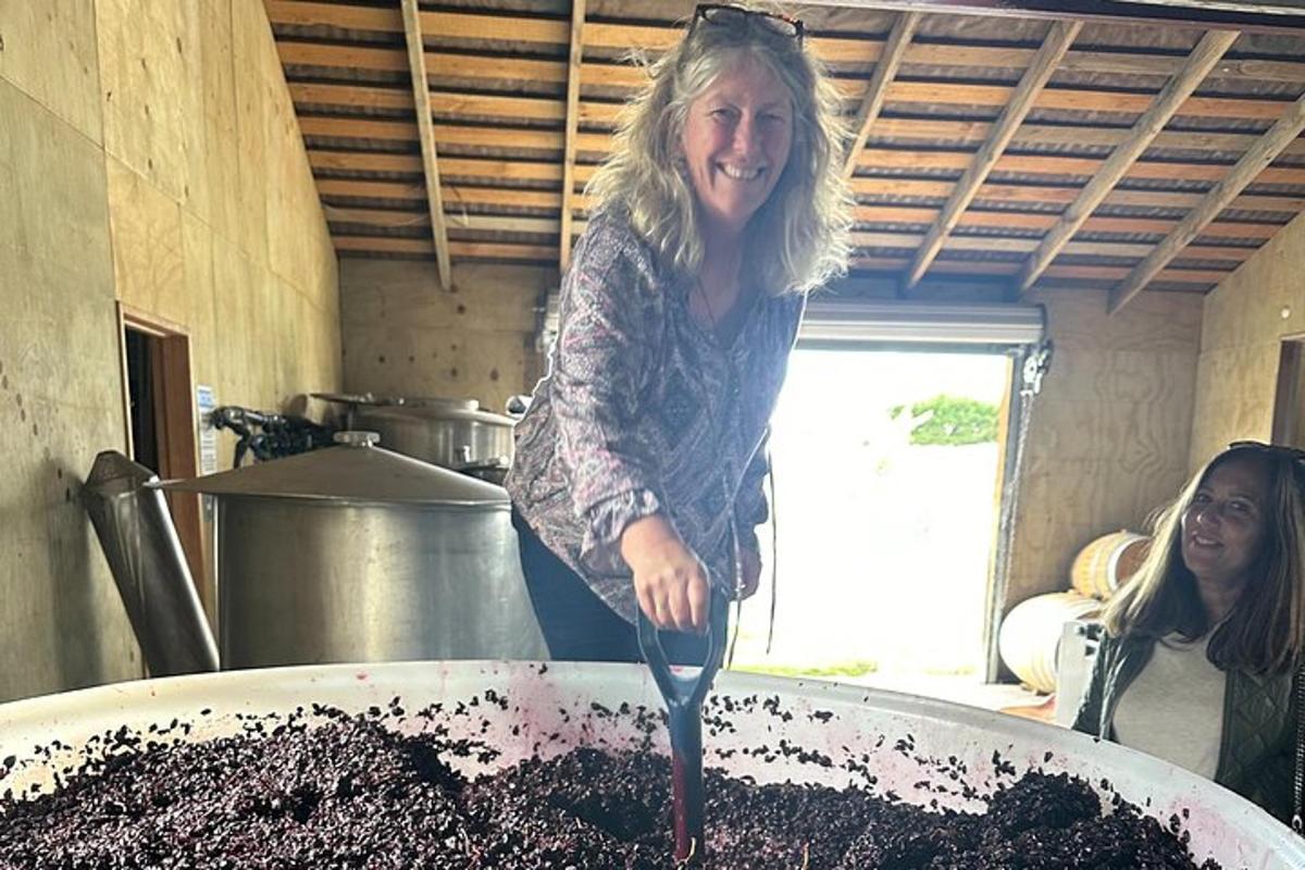 žena držící lžíci ve velkém hrnci s hlínou