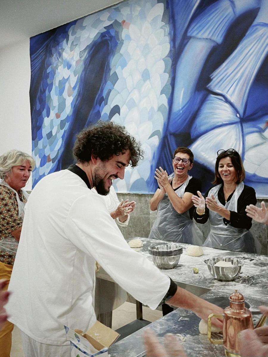 a man standing in front of a table preparing food