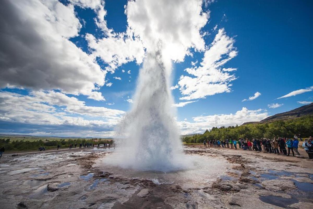 ein Geysir auf einem Feld mit einer Menschenmenge
