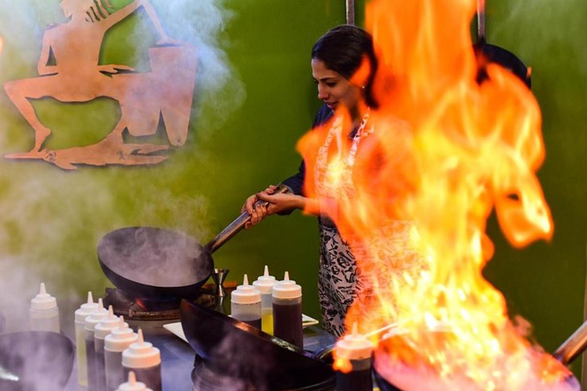 una mujer cocinando en un wok sobre el fuego