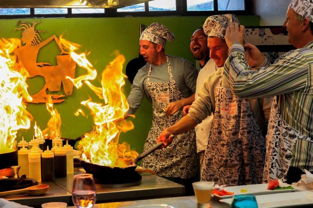 Un grupo de personas de pie frente a un pastel en llamas.