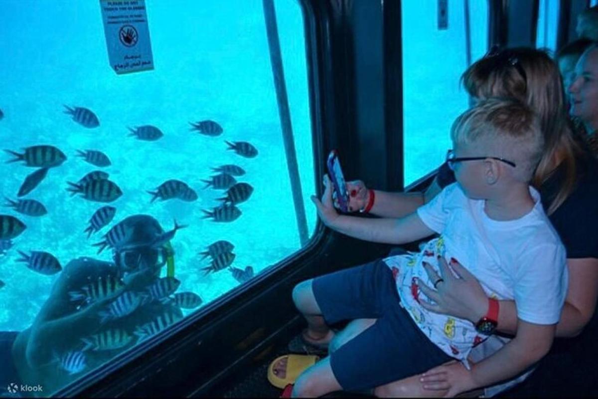 una coppia di bambini che guardano i pesci in un acquario