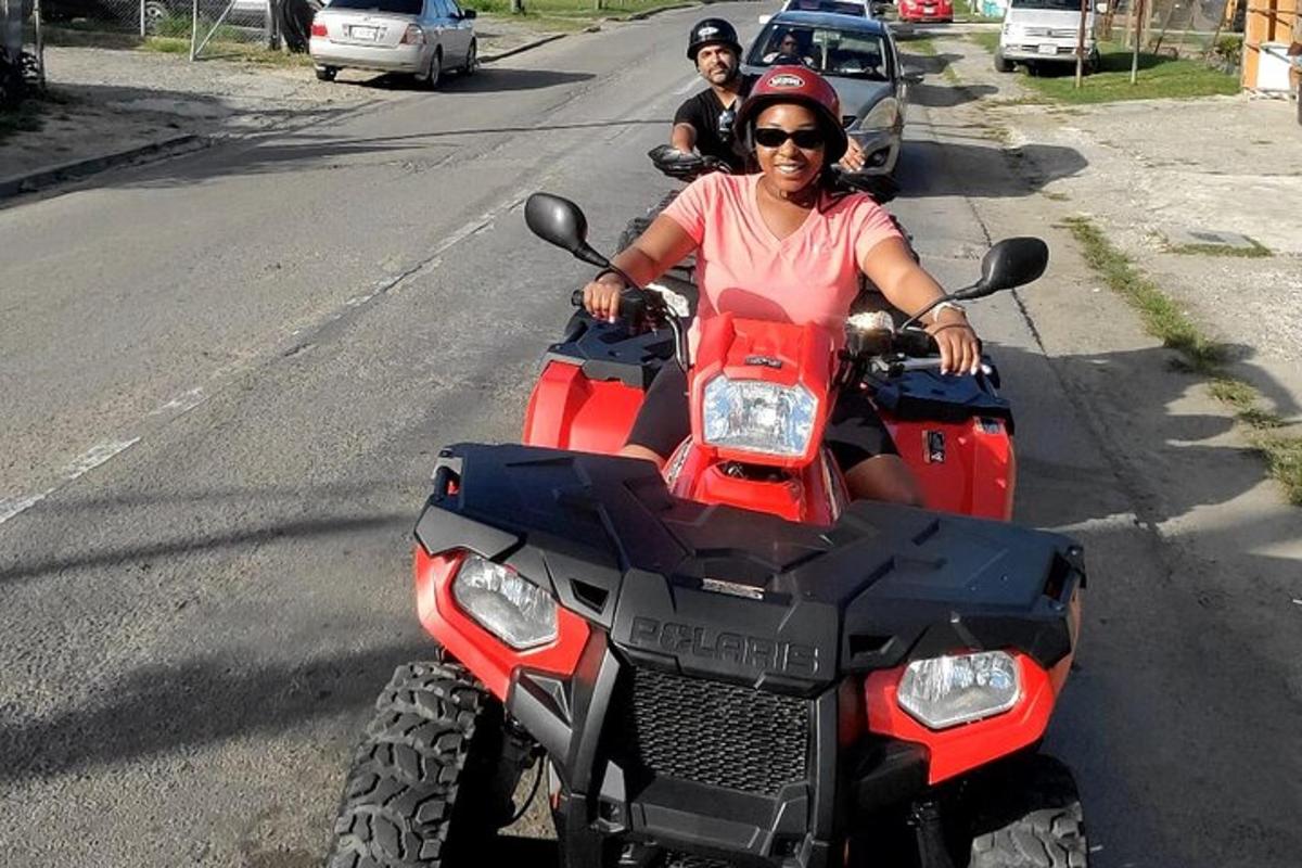 una dona conduint un quad vermell pel carrer