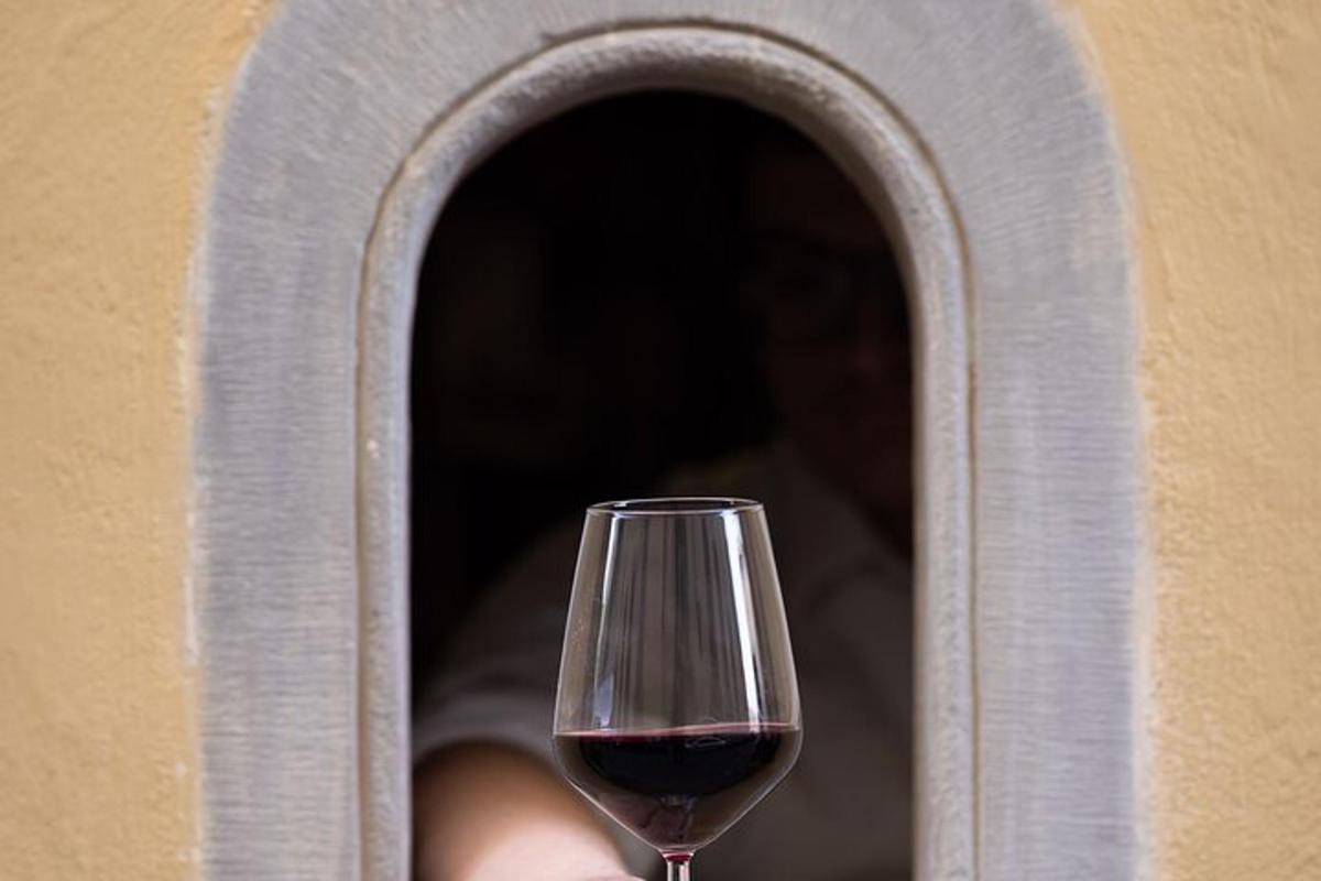 una copa de vi negre asseguda a la finestra