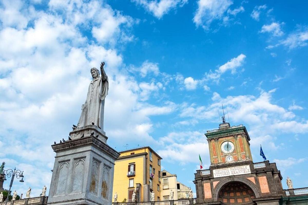 una statua di fronte a un edificio con una torre dell'orologio