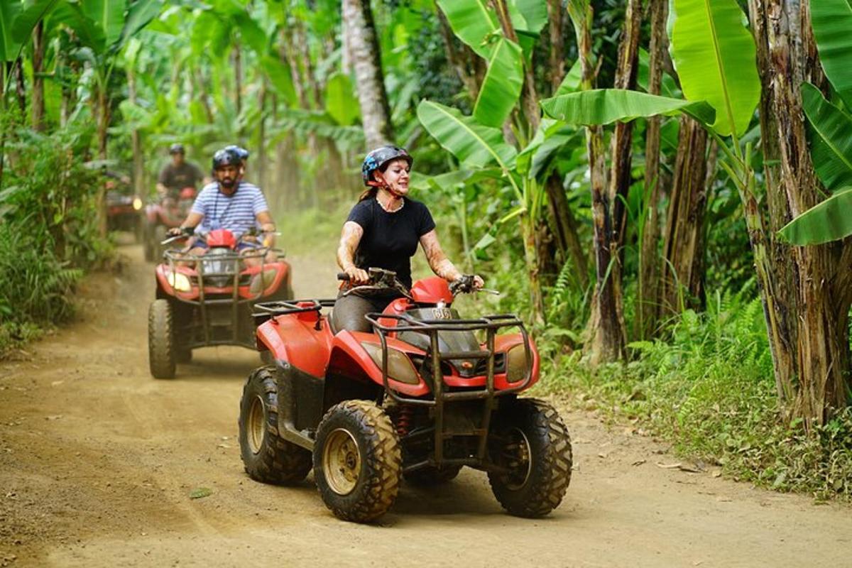 două persoane care călătoresc pe ATV-uri pe un drum de pământ