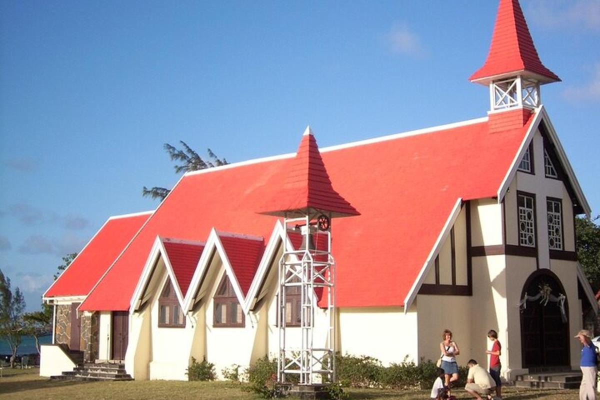 eine Kirche mit einem roten Dach und Menschen, die davor stehen