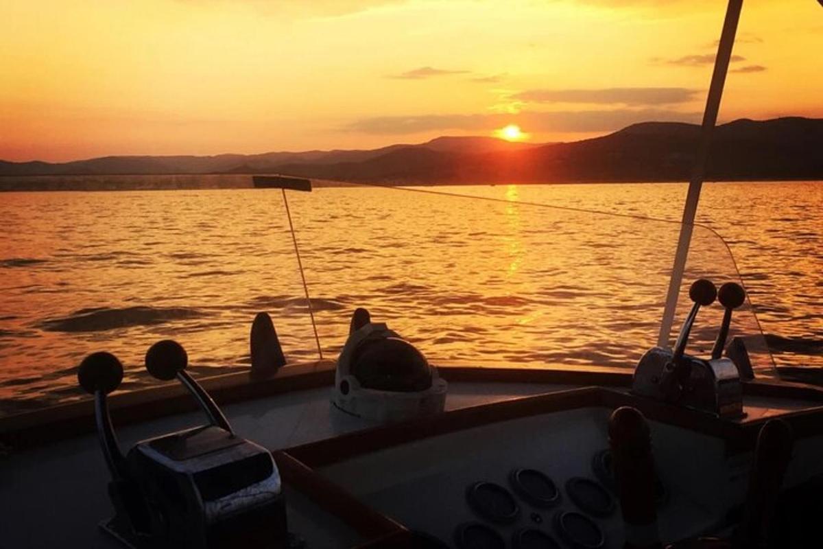 una barca sull'acqua con un tramonto sullo sfondo