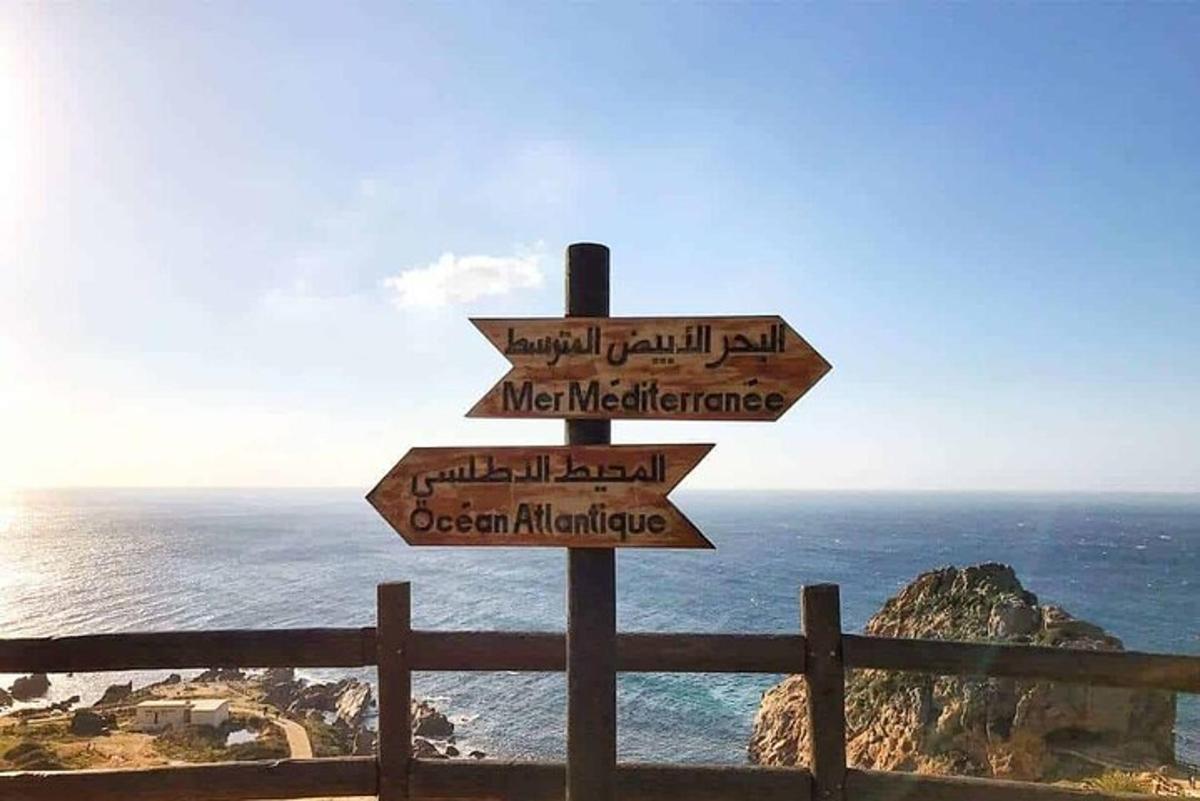 uma placa com setas apontando em diferentes direções perto do oceano