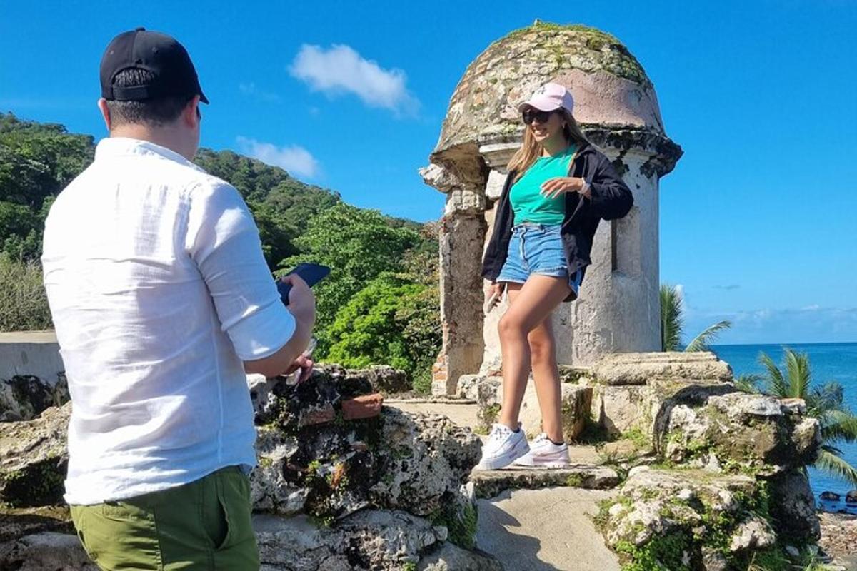moški fotografira žensko, ki stoji na kipu