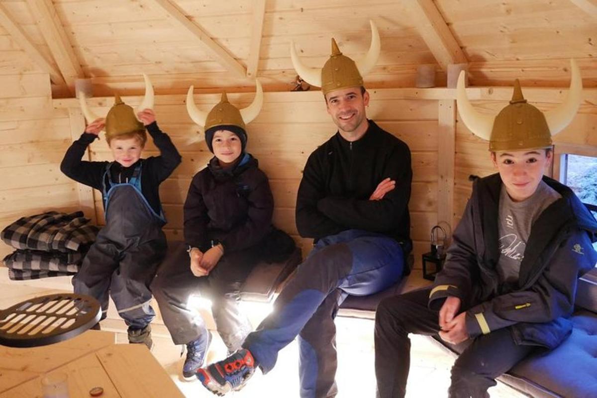 skupina lidí sedících v chatě s rohy na hlavách