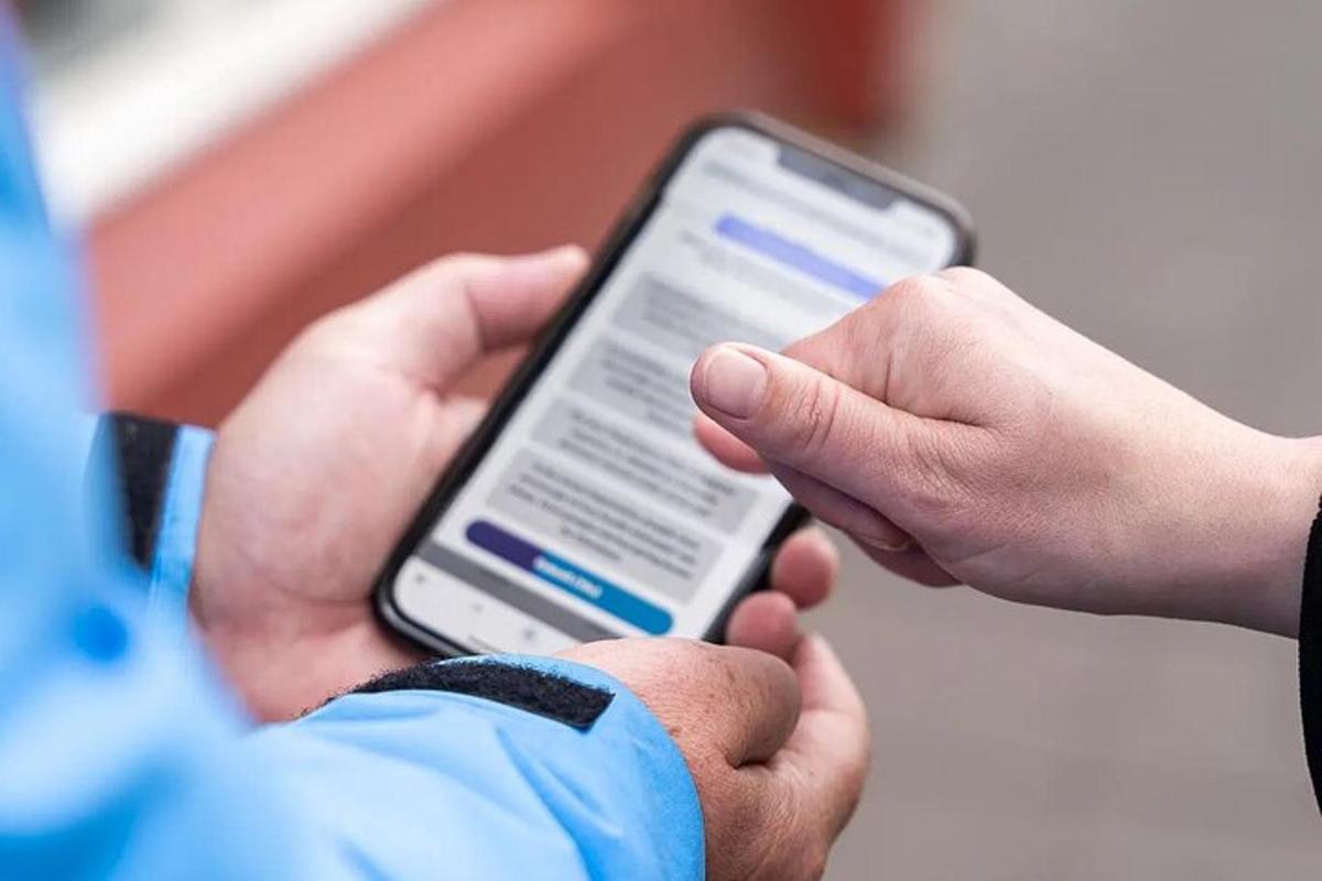 osoba držící v ruce mobilní telefon
