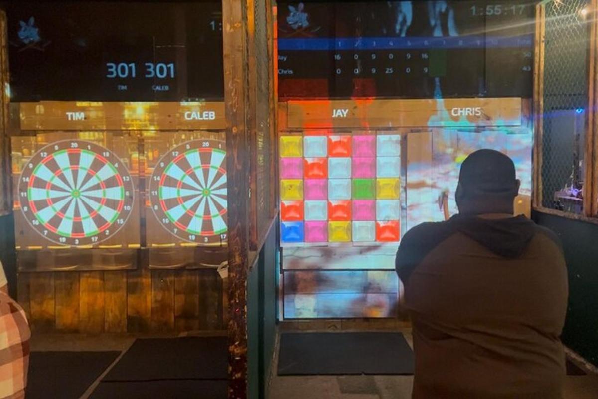 一个人站在窗前，手里拿着飞镖