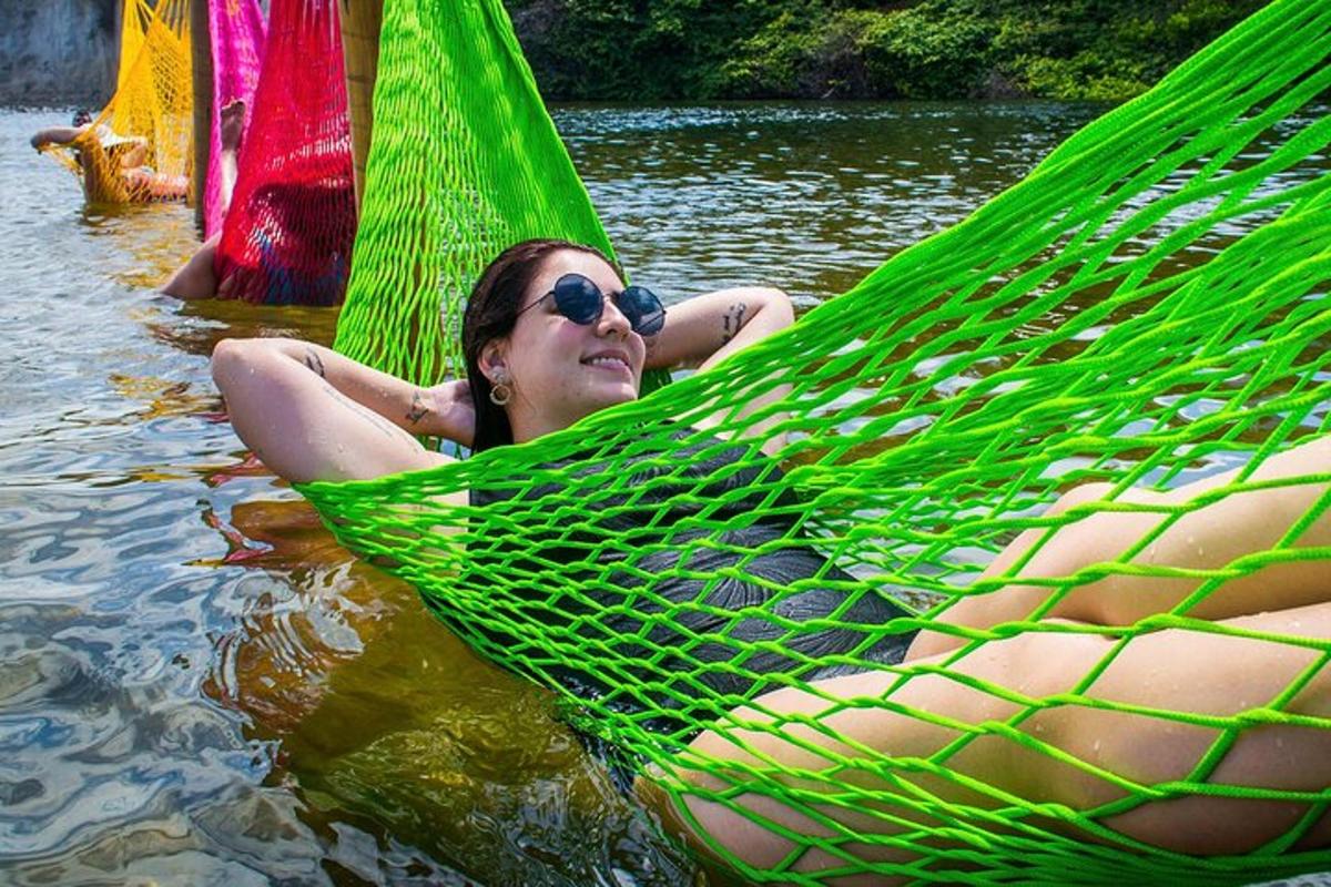a woman laying in the water in a green net