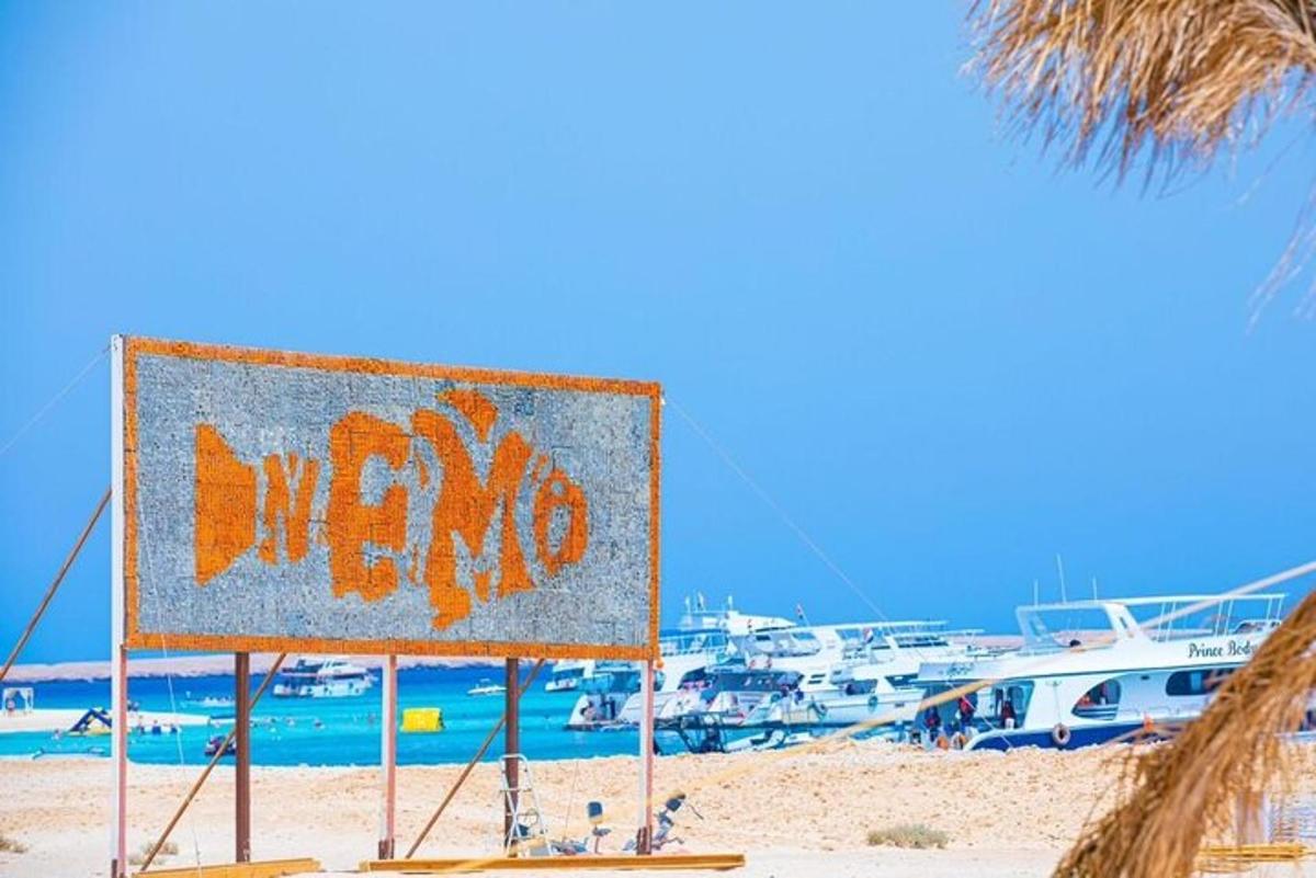 uma placa em uma praia com barcos na água