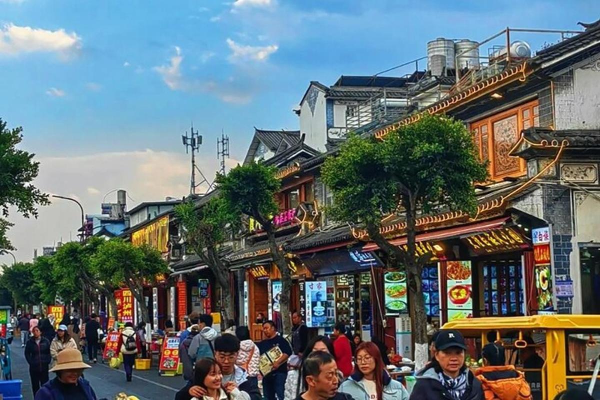 a crowd of people walking down a street with buildings