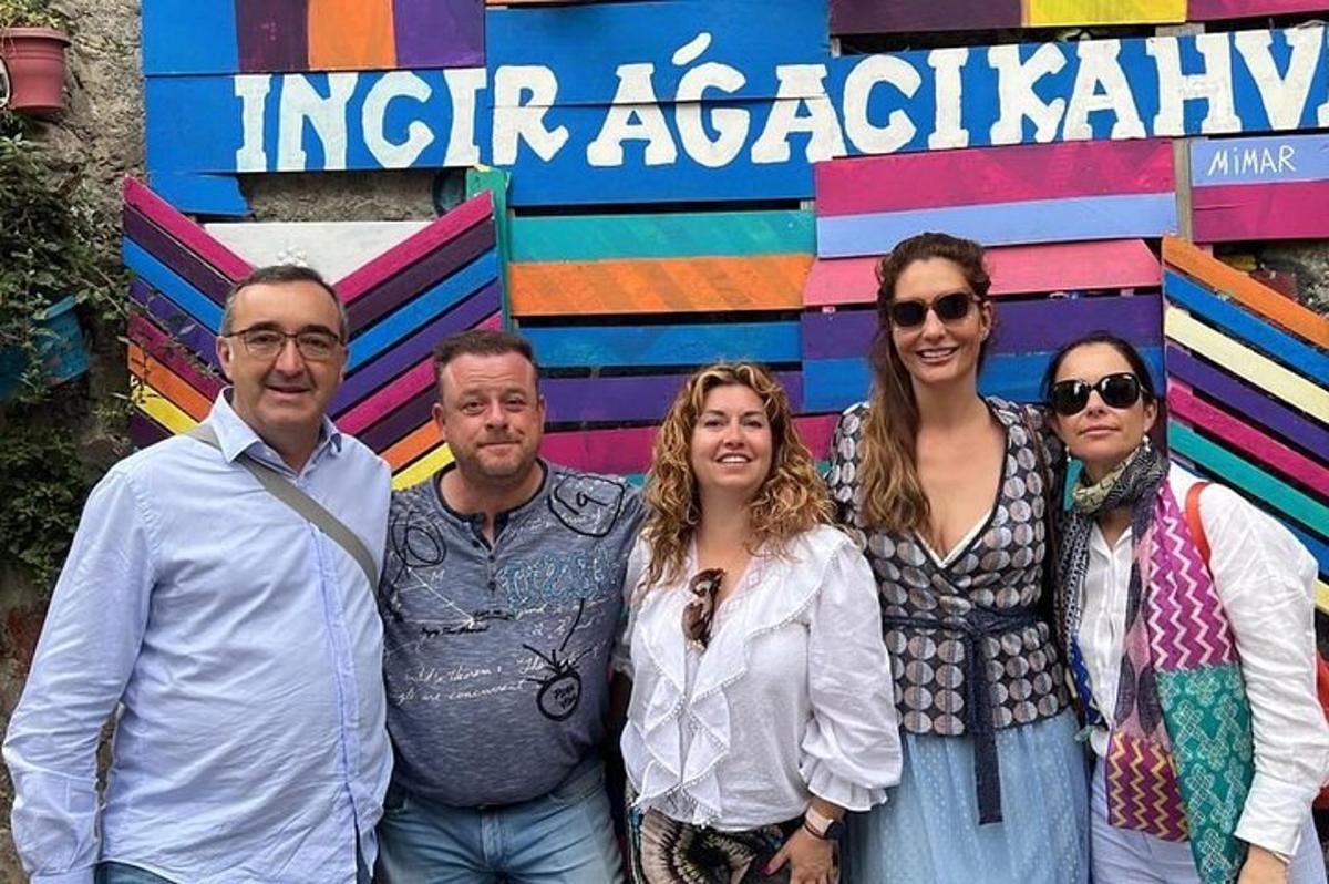um grupo de pessoas em pé em frente a uma placa