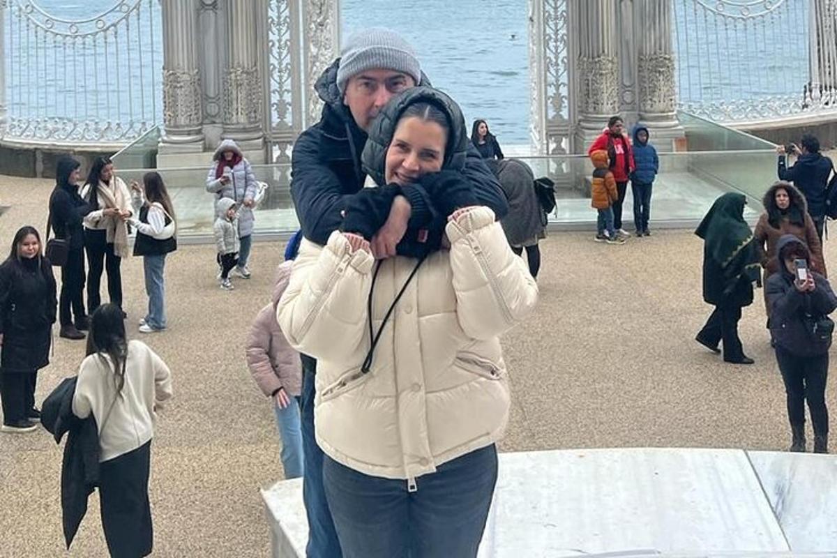 um homem e uma mulher se abraçando em frente a um prédio