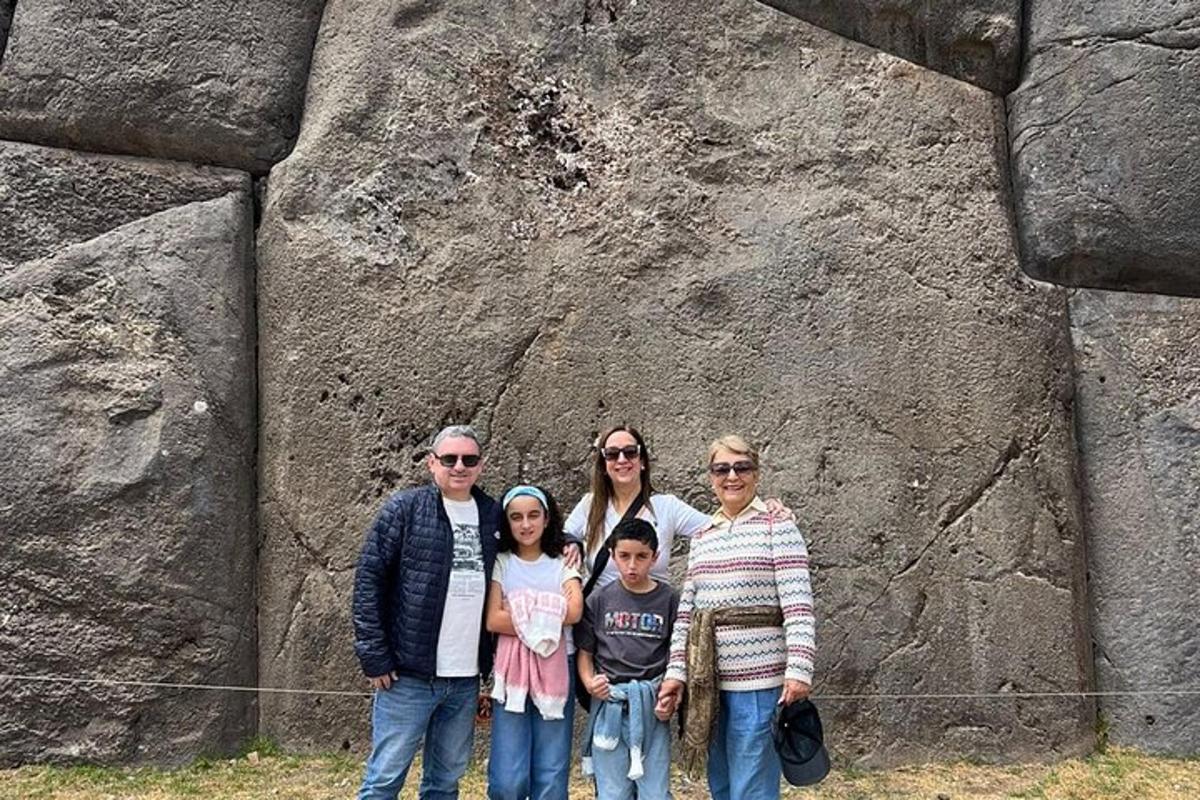 o familie care pozează în fața unui zid de stâncă