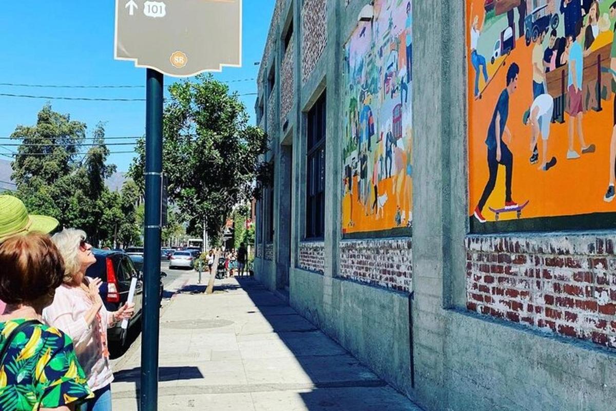 dues persones mirant un mural en un edifici