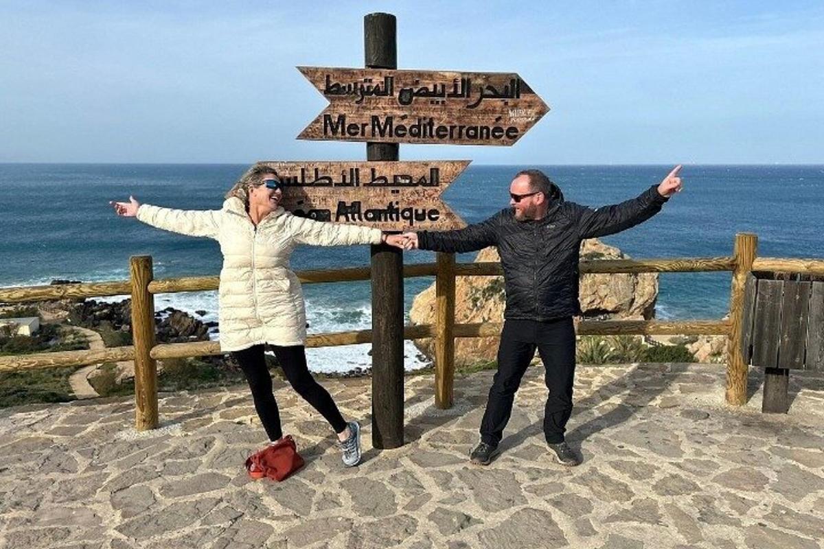 bir sokak tabelasının yanında duran bir erkek ve bir kadın
