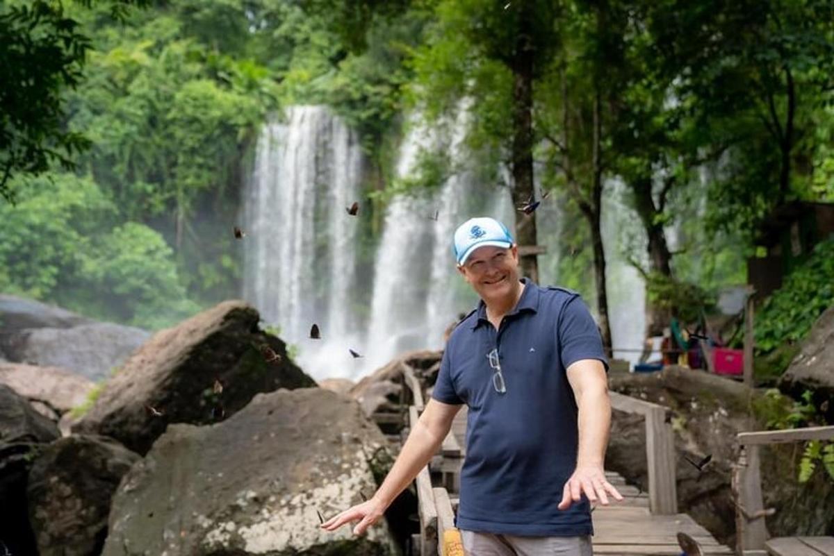 un uomo in piedi davanti a una cascata