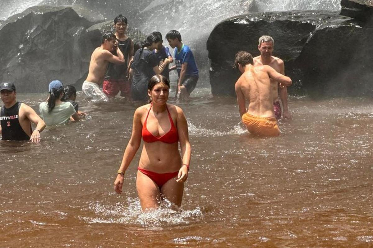 Una mujer caminando por el agua en un grupo de personas.